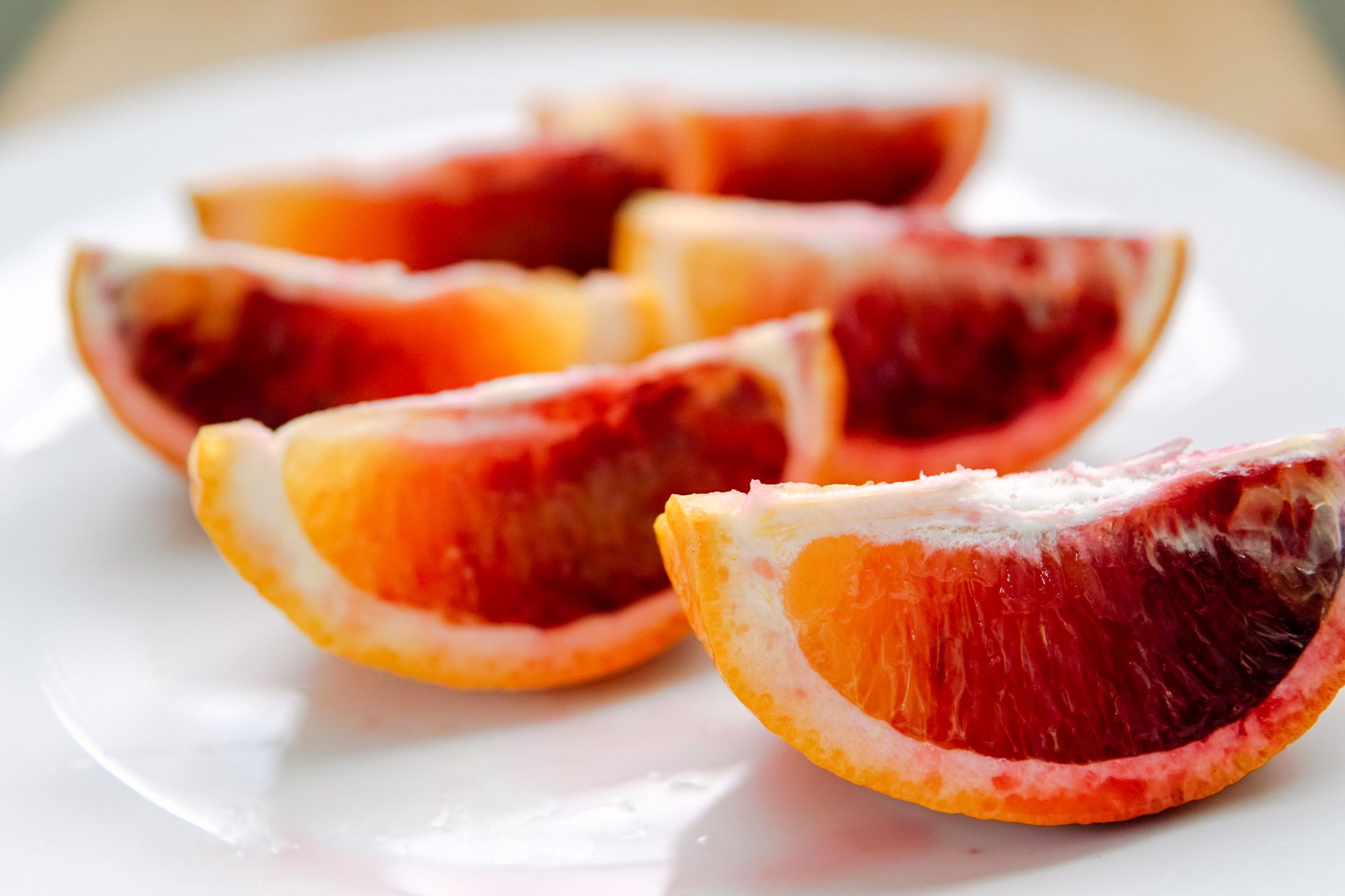 Freshly sliced blood orange fruit on ceramic plate